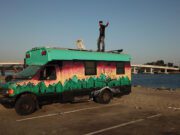 Digital Nomad Living in a School Bus standing on roof of skoolie